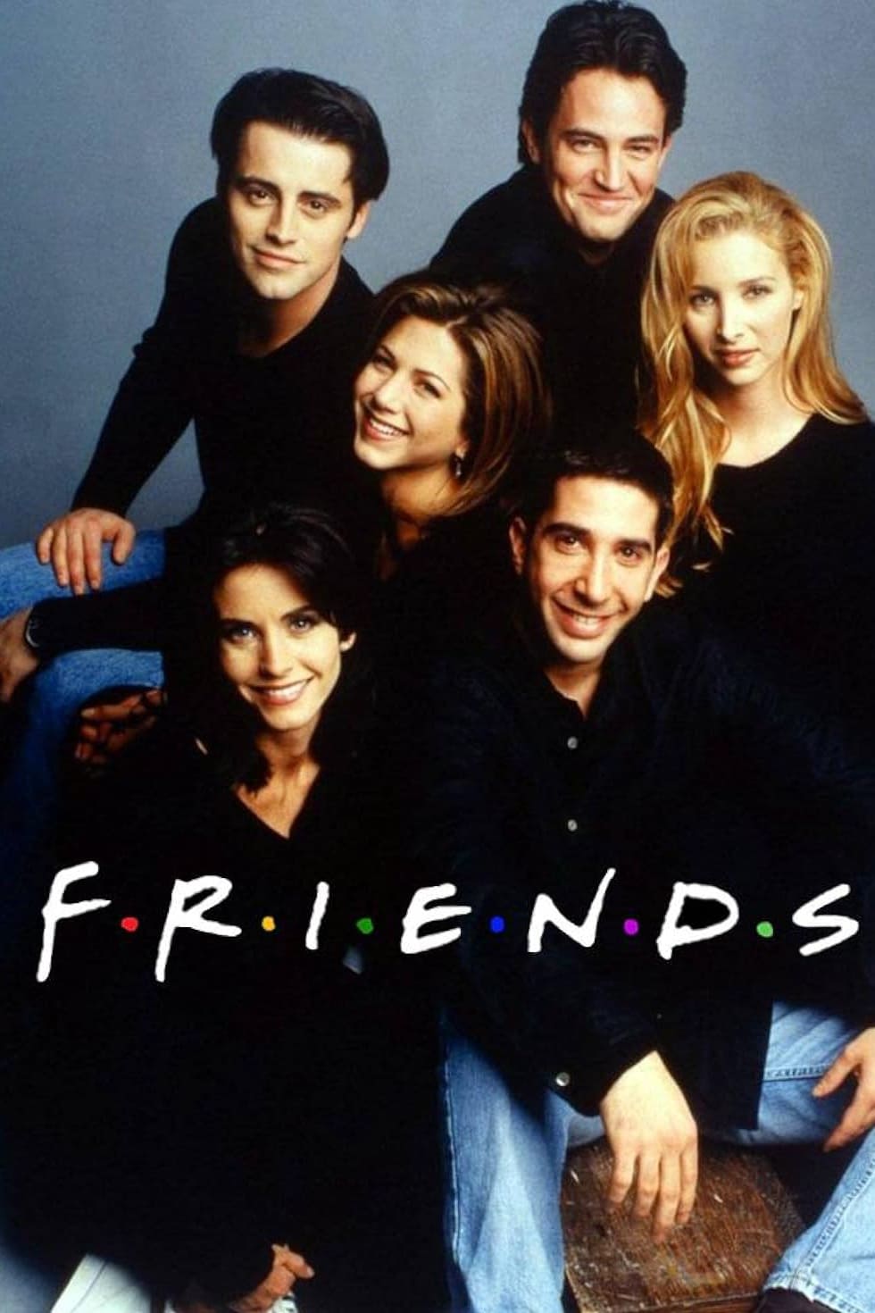 Six people sit and smile together against a neutral background. The word FRIENDS appears in white text with colored dots between the letters across the bottom of the image, reminiscent of enjoying your favorite shows on IPTV Netherland.